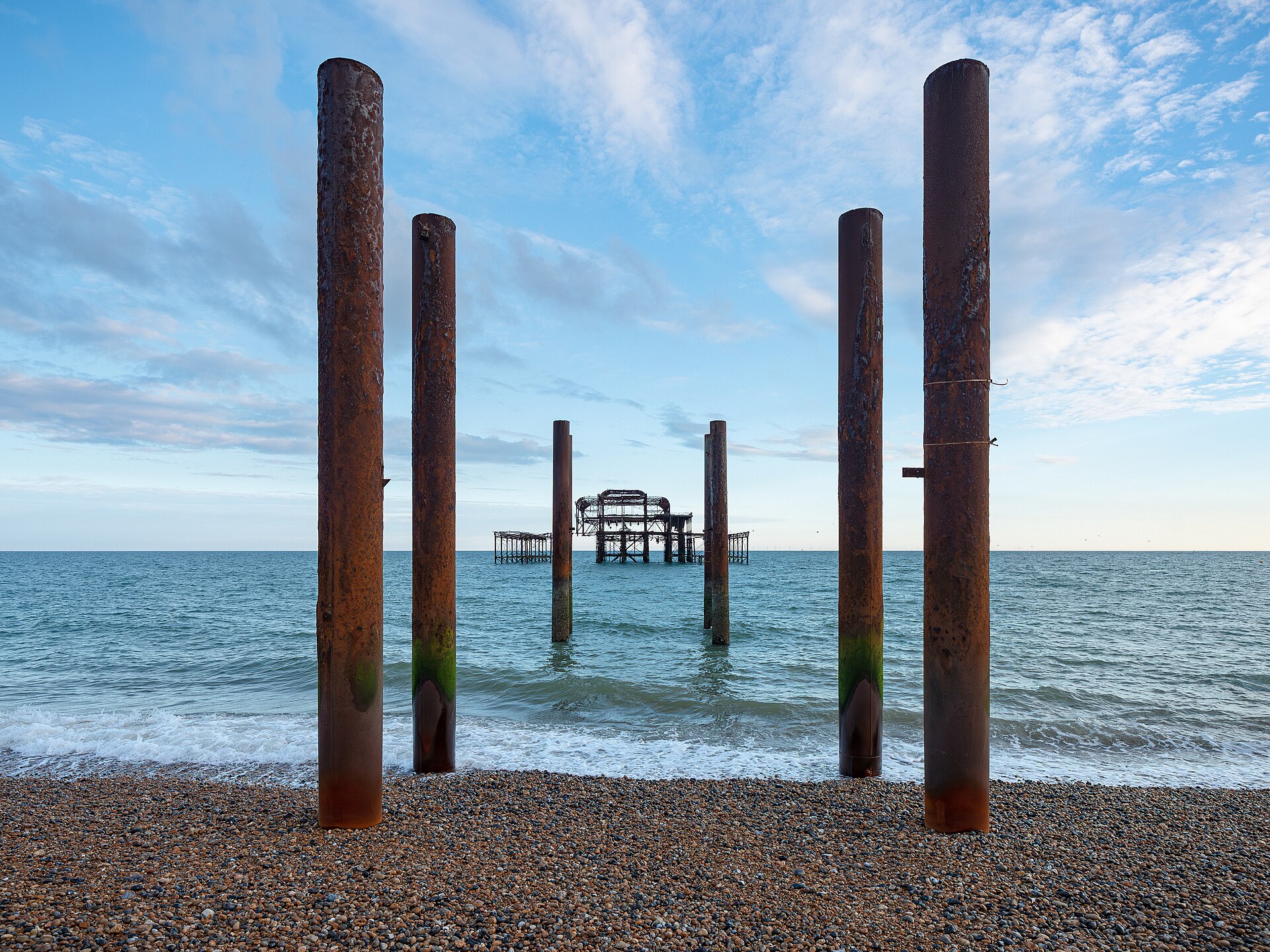 West Pier ruins and old pier pilings at golden hour, calm sea