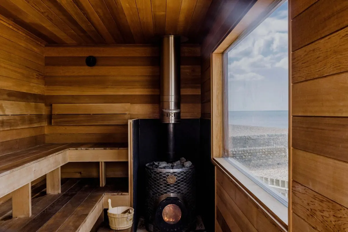Inside the Beach Box sauna: wood-burning stove and a window onto the sea
