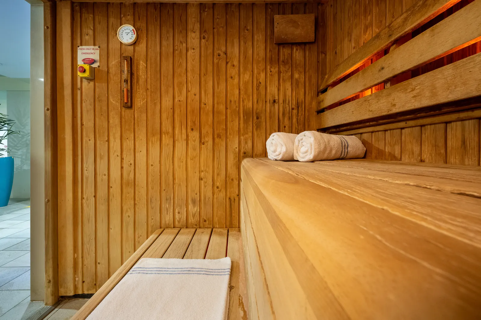 Wood-panelled sauna with benches and towels